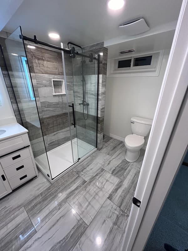 Modern basement bathroom renovation in Dorchester Ontario with tiled shower and vanity