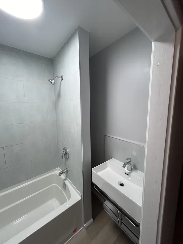 Bathroom renovation in Chatham Ontario rental with new tub, tiled surround and ventilation upgrade